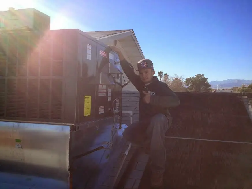 HVAC technician performing Boiler Repair on a rooftop unit in Norfolk